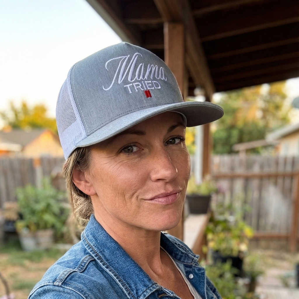 Woman wearing a snapback hat with 'Mama Tried' text in an outdoor setting