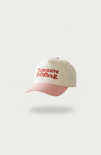 Beige and pink snapback hat with 'Expensive and Difficult' text on a white background