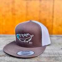 Rootbeer and white snapback cap with teal and white feather design on a wooden surface