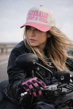 Woman riding a motorcycle wearing a cap and gloves with text