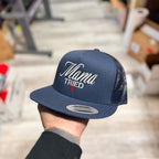 Navy snapback hat with 'Mama Tried' text held by a person against a neutral background