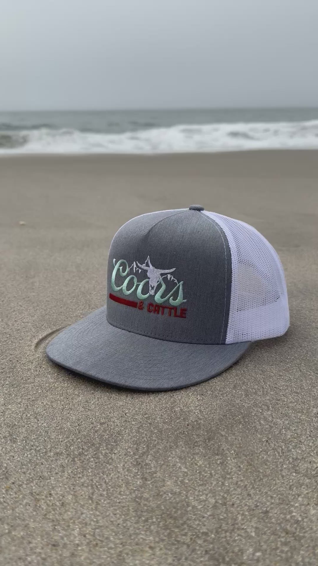 short video of the coors and cattle hat sitting in the sand on the beach
