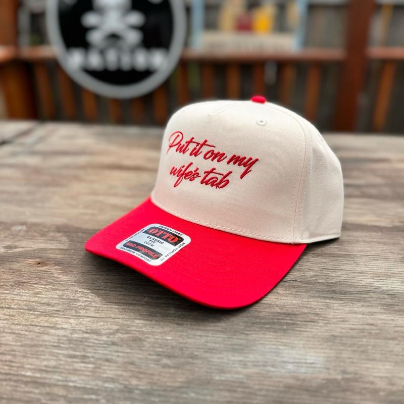 Red and beige cap with text on a wooden surface