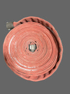 Roll of red firehose on a gray background