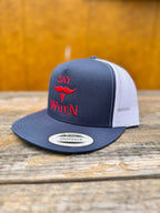 navy and white snapback hat with red 'SAY WHEN' text on a wooden table