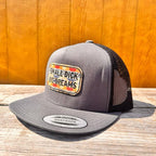 charcoal and black snapback hat with 'Small D*ck Big Dreams' patch on a wooden surface.