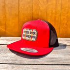 Red and black snapback hat with 'Small D*ck Big Dreams' patch on a wooden surface.