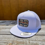White snapback hat with 'Small D*ck Big Dreams' patch on a wooden surface.